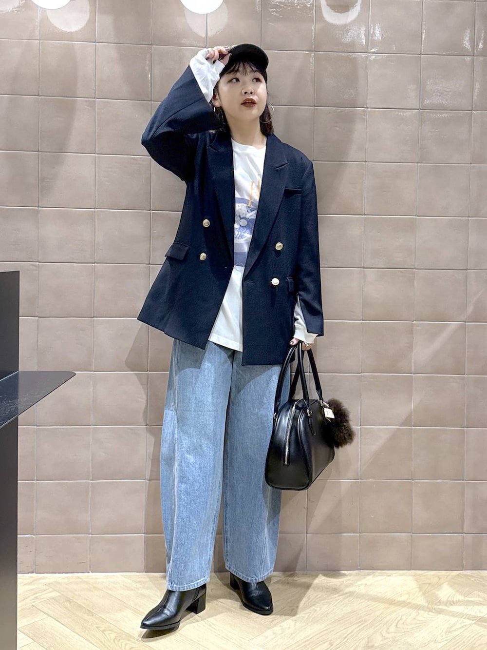 ブルー系のデニムパンツ、ブラック系のブーツ、ブルー系のテーラードジャケットを着用したレディースの秋コーディネートの2枚目の写真