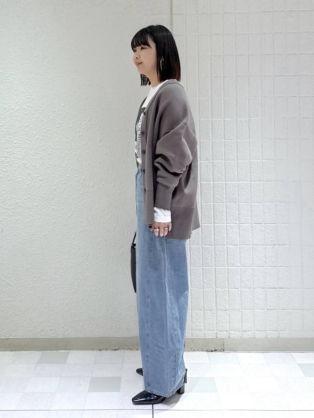 ブルー系のデニムパンツ、グレー系のカーディガン/ボレロ、ブラック系のその他シューズを着用したレディースの冬コーディネートの5枚目の写真