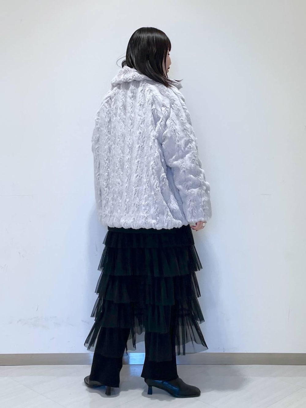 ブラック系のスウェット、ブラック系のブーツ、グレー系のブルゾンを着用したレディースの冬コーディネートの3枚目の写真