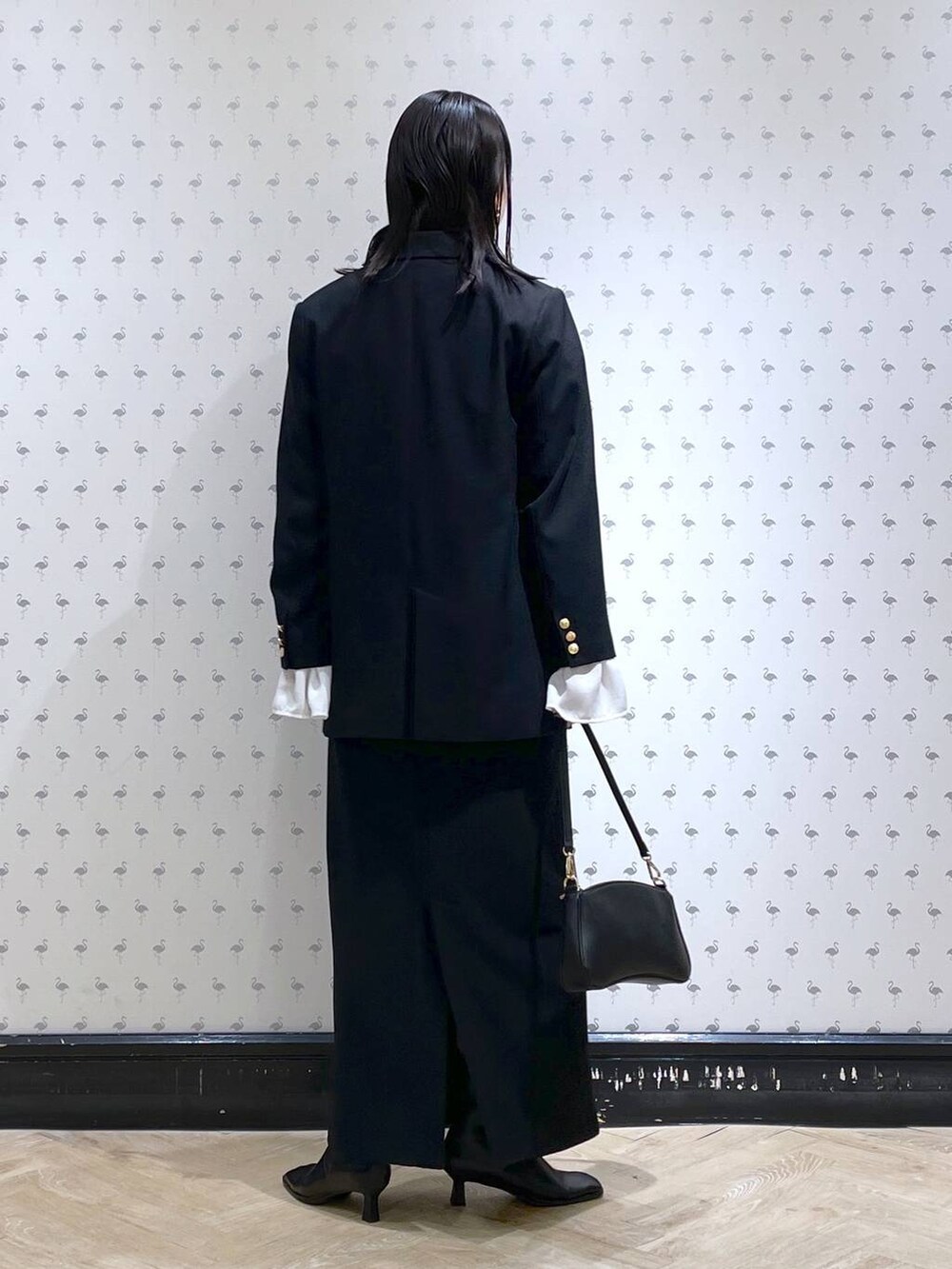 ブラック系のショルダーバッグ、ブラック系のブーツ、ブラック系のスカートを着用したレディースの冬コーディネートの3枚目の写真