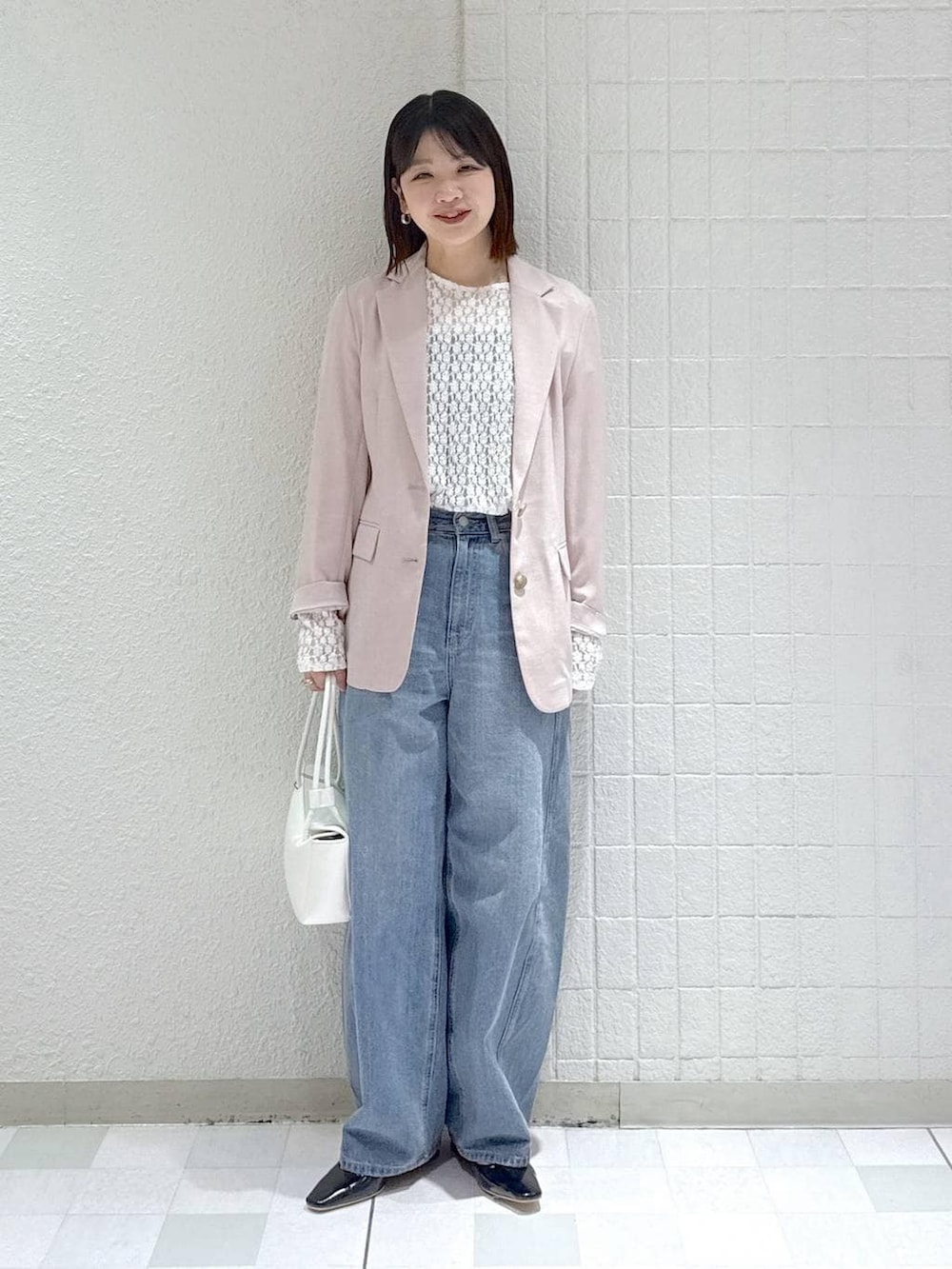 ブルー系のデニムパンツ、ホワイト系のTシャツ/カットソー、ホワイト系のショルダーバッグを着用したレディースの春コーディネートの2枚目の写真