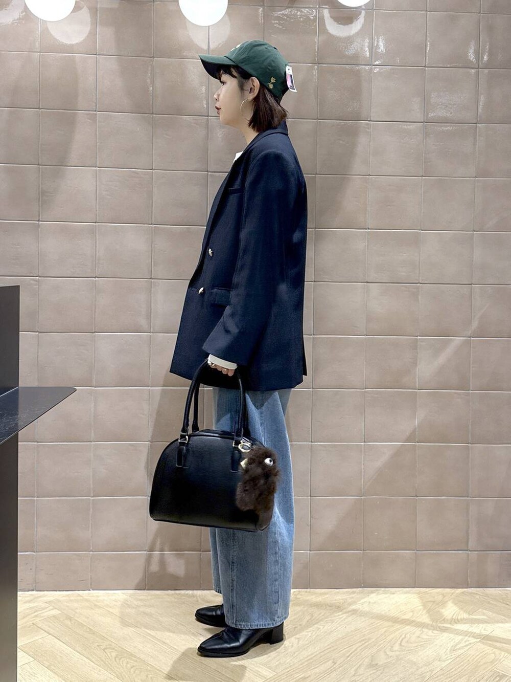 ブルー系のデニムパンツ、ブラック系のブーツ、ブルー系のテーラードジャケットを着用したレディースの秋コーディネートの5枚目の写真