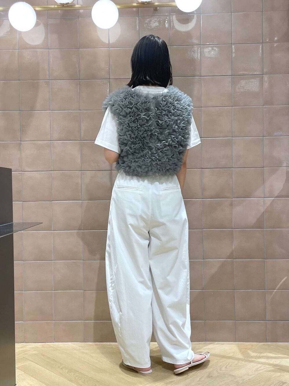 グリーン系のベスト、ホワイト系のサンダル、ホワイト系のその他パンツを着用したレディースの夏コーディネートの3枚目の写真