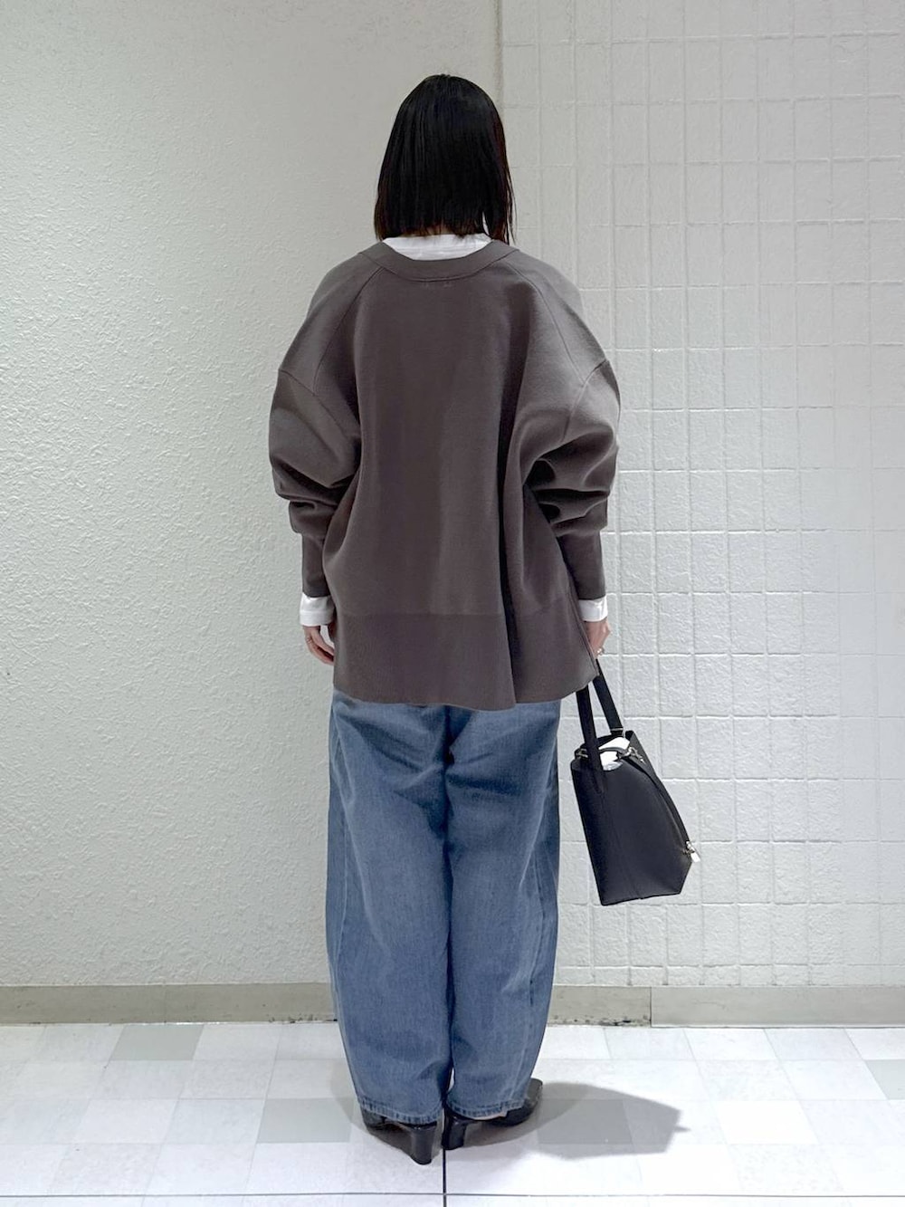 ブルー系のデニムパンツ、グレー系のカーディガン/ボレロ、ブラック系のその他シューズを着用したレディースの冬コーディネートの4枚目の写真