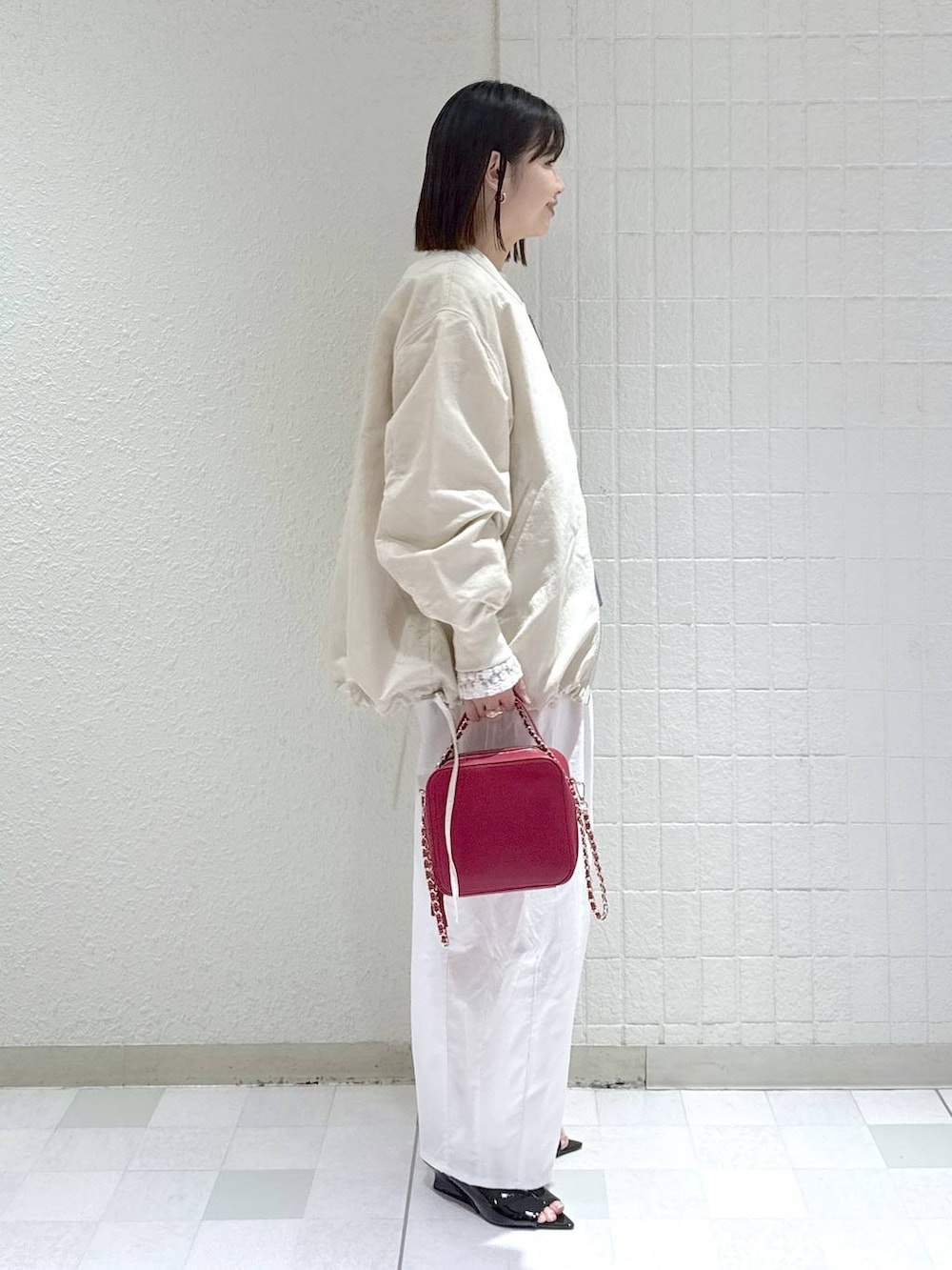 ベージュ系のMA-1、ホワイト系のTシャツ/カットソー、ブルー系のベストを着用したレディースの春コーディネートの3枚目の写真