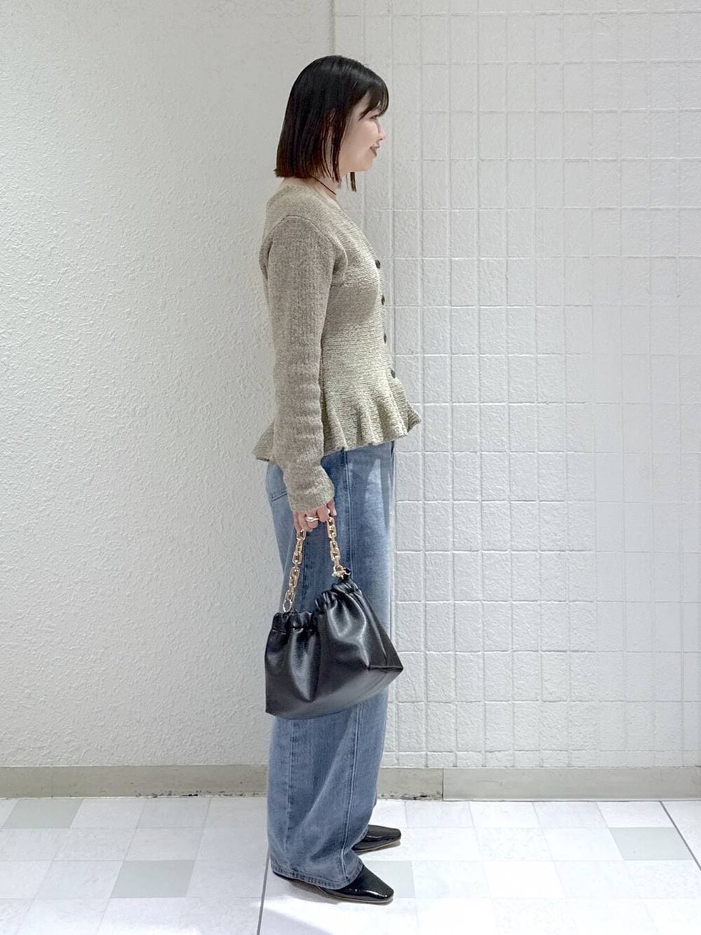 ブルー系のデニムパンツ、ブラック系のショルダーバッグ、ブラック系のパンプスを着用したレディースの春コーディネートの2枚目の写真