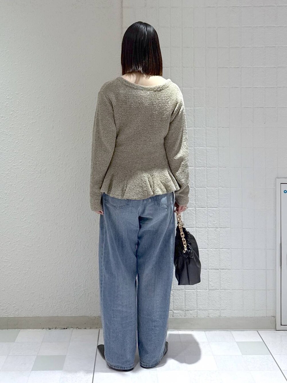 ブルー系のデニムパンツ、ブラック系のショルダーバッグ、ブラック系のパンプスを着用したレディースの春コーディネートの3枚目の写真