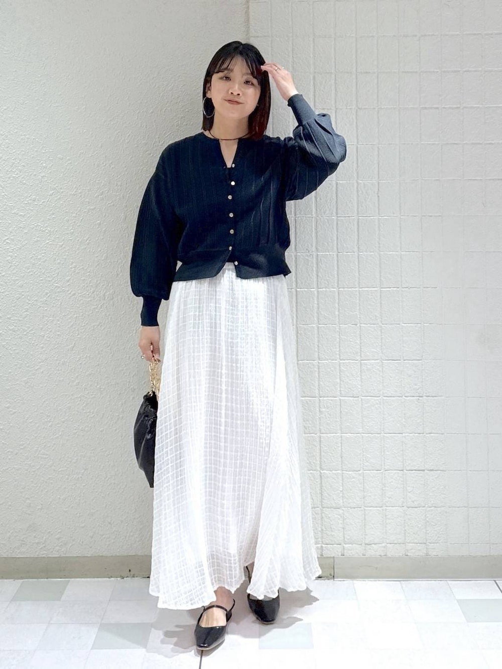 ブルー系のカーディガン/ボレロ、ブラック系のショルダーバッグ、ブラック系のパンプスを着用したレディースの春コーディネートの2枚目の写真