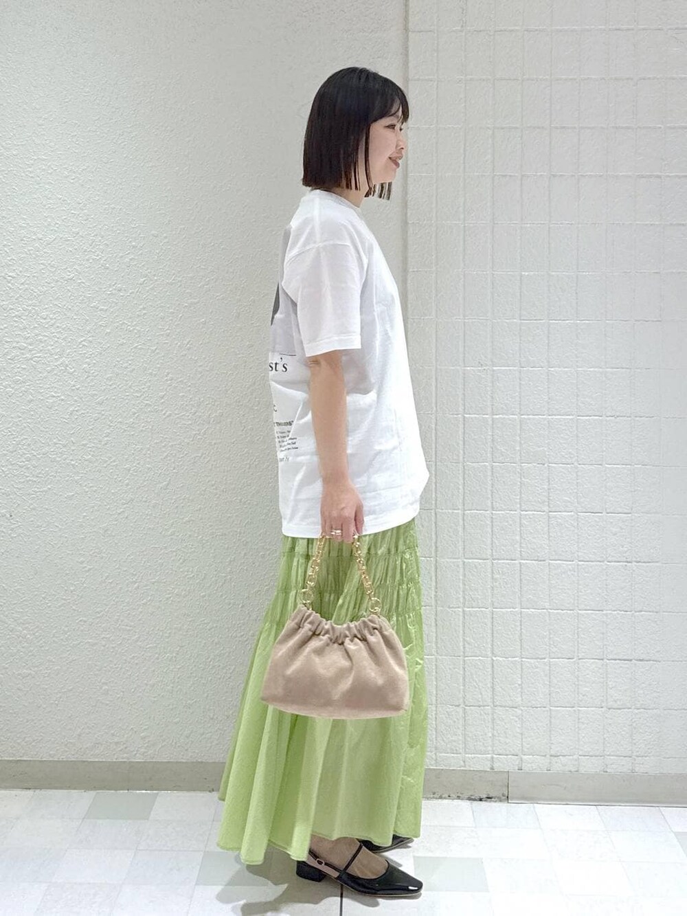 ベージュ系のショルダーバッグ、グリーン系のスカート、ブラック系のその他シューズを着用したレディースの冬コーディネートの2枚目の写真