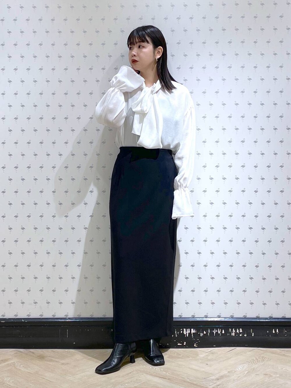 ブラック系のショルダーバッグ、ブラック系のブーツ、ブラック系のスカートを着用したレディースの冬コーディネートの7枚目の写真