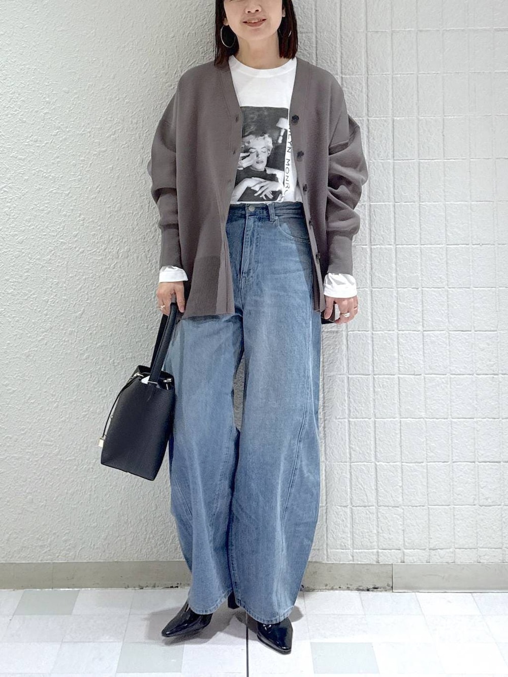 ブルー系のデニムパンツ、グレー系のカーディガン/ボレロ、ブラック系のその他シューズを着用したレディースの冬コーディネートの6枚目の写真