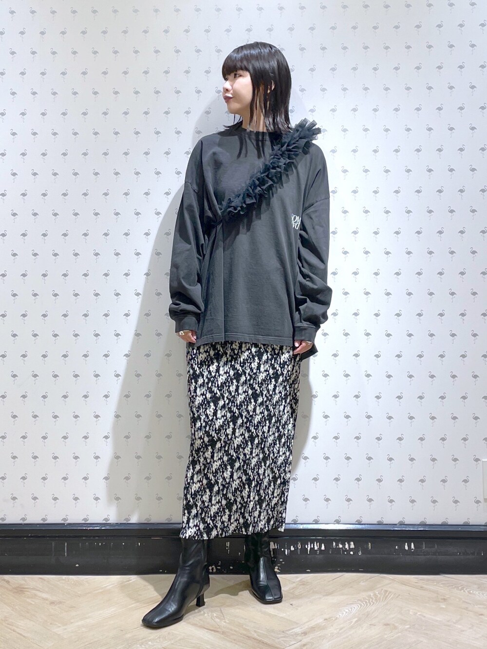 グレー系のTシャツ/カットソー、グレー系のスカート、ブラック系のブーツを着用したレディースの秋コーディネートの2枚目の写真