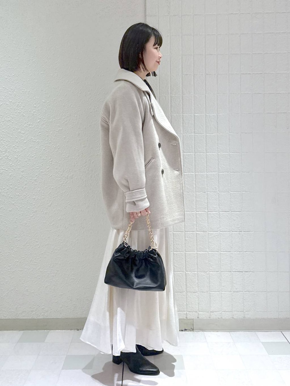 ベージュ系のピーコート、ブラック系のブーツ、ブラウン系のニット/セーターを着用したレディースの冬コーディネートの3枚目の写真