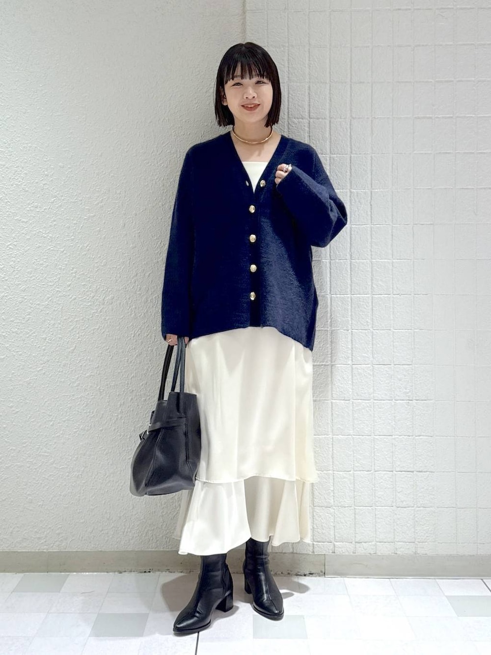 ブルー系のカーディガン/ボレロ、ブラック系のブーツ、ホワイト系のワンピースを着用したレディースの秋コーディネートの2枚目の写真