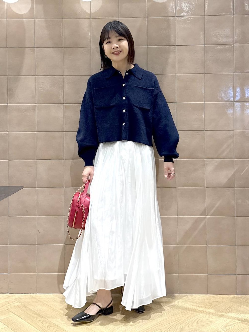 ホワイト系のスカート、ブルー系のカーディガン/ボレロ、ブラック系のその他シューズを着用したレディースの冬コーディネートの2枚目の写真