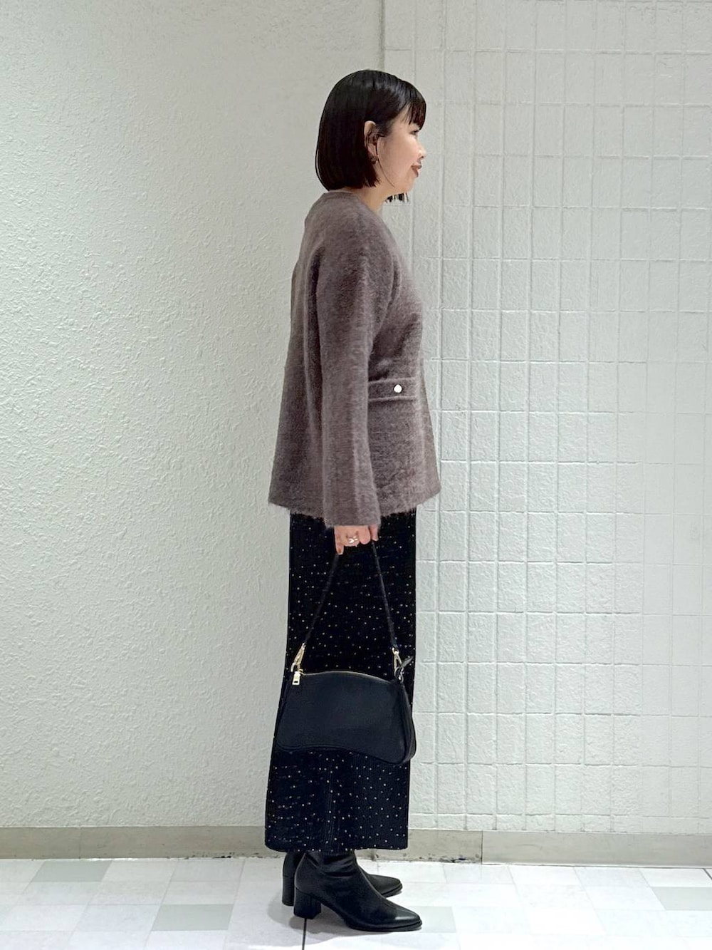 ブラック系のブーツ、その他のスカート、ブラウン系のカーディガン/ボレロを着用したレディースの秋コーディネートの3枚目の写真