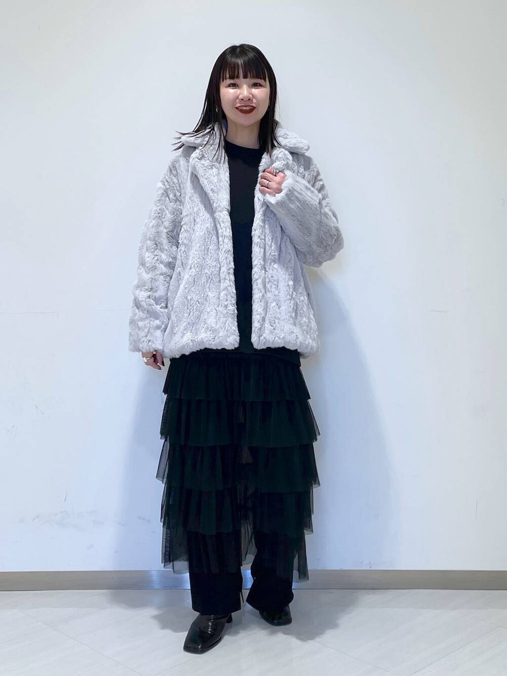 ブラック系のスウェット、ブラック系のブーツ、グレー系のブルゾンを着用したレディースの冬コーディネートの2枚目の写真