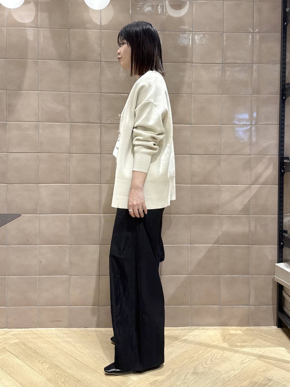 ホワイト系のカーディガン/ボレロ、ブラック系のその他パンツ、ブラック系のショルダーバッグを着用したレディースの春コーディネートの4枚目の写真