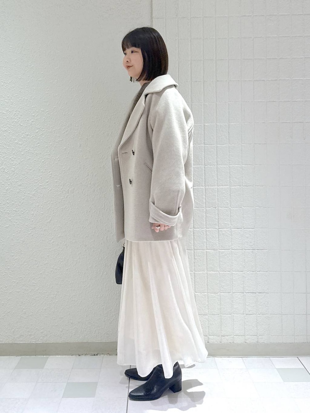 ベージュ系のピーコート、ブラック系のブーツ、ブラウン系のニット/セーターを着用したレディースの冬コーディネートの5枚目の写真