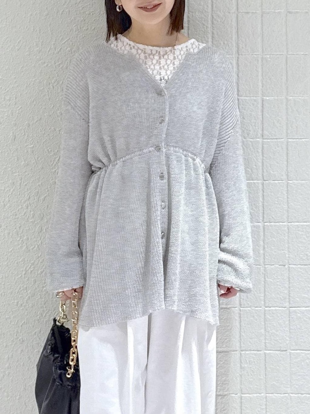 ホワイト系のTシャツ/カットソー、ブラック系のショルダーバッグ、グレー系のカーディガン/ボレロを着用したレディースの春コーディネートの5枚目の写真