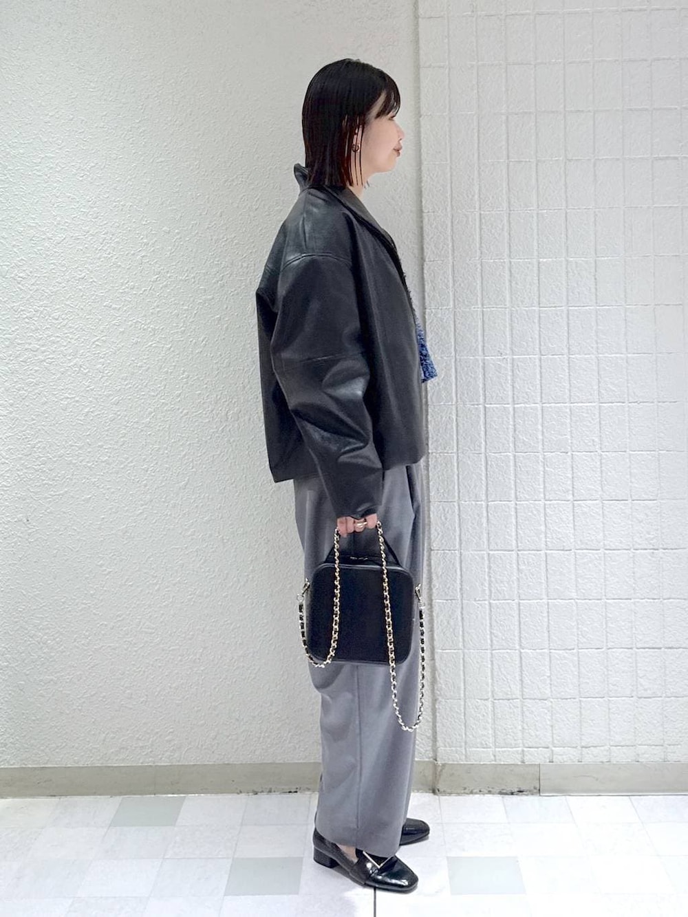 ホワイト系のタンクトップ、ブラック系のローファー、ブルー系のカーディガン/ボレロを着用したレディースの春コーディネートの2枚目の写真