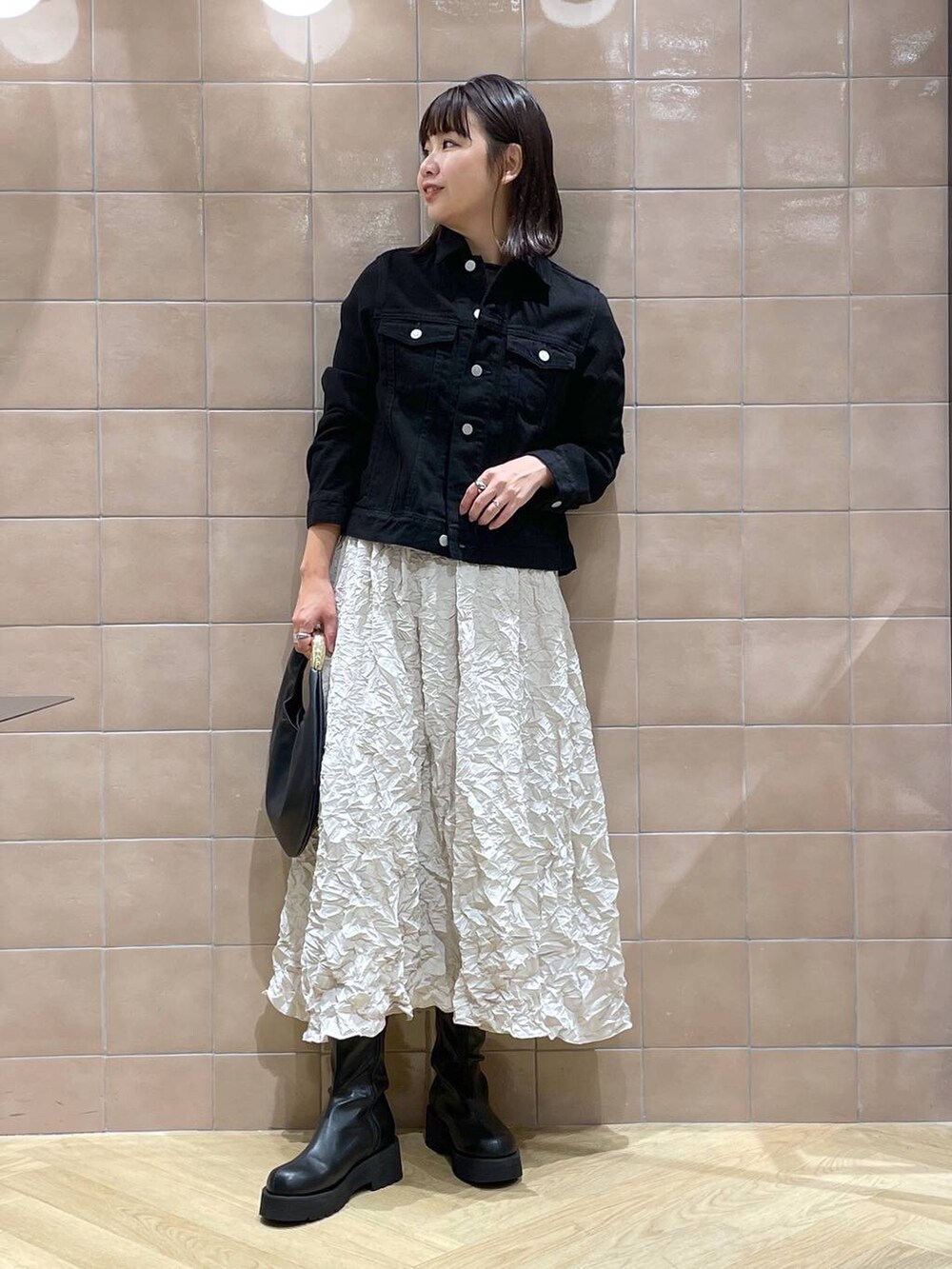 ブラック系のデニムジャケット、ブラック系のハンドバッグ、ブラック系のシャツ/ブラウスを着用したレディースの秋コーディネートの5枚目の写真