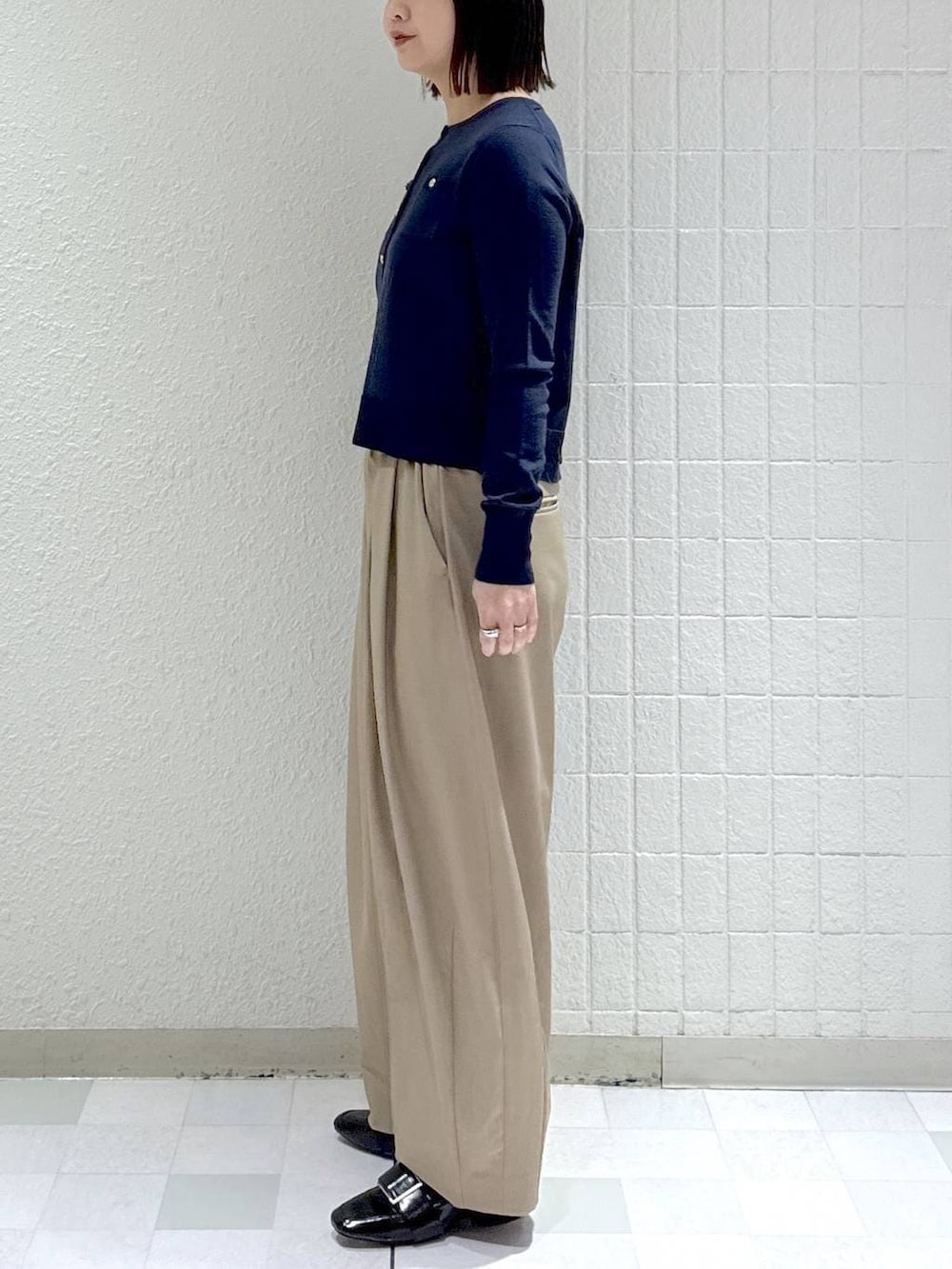 ベージュ系のスラックス、ブラック系のローファー、ブルー系のカーディガン/ボレロを着用したレディースの冬コーディネートの5枚目の写真