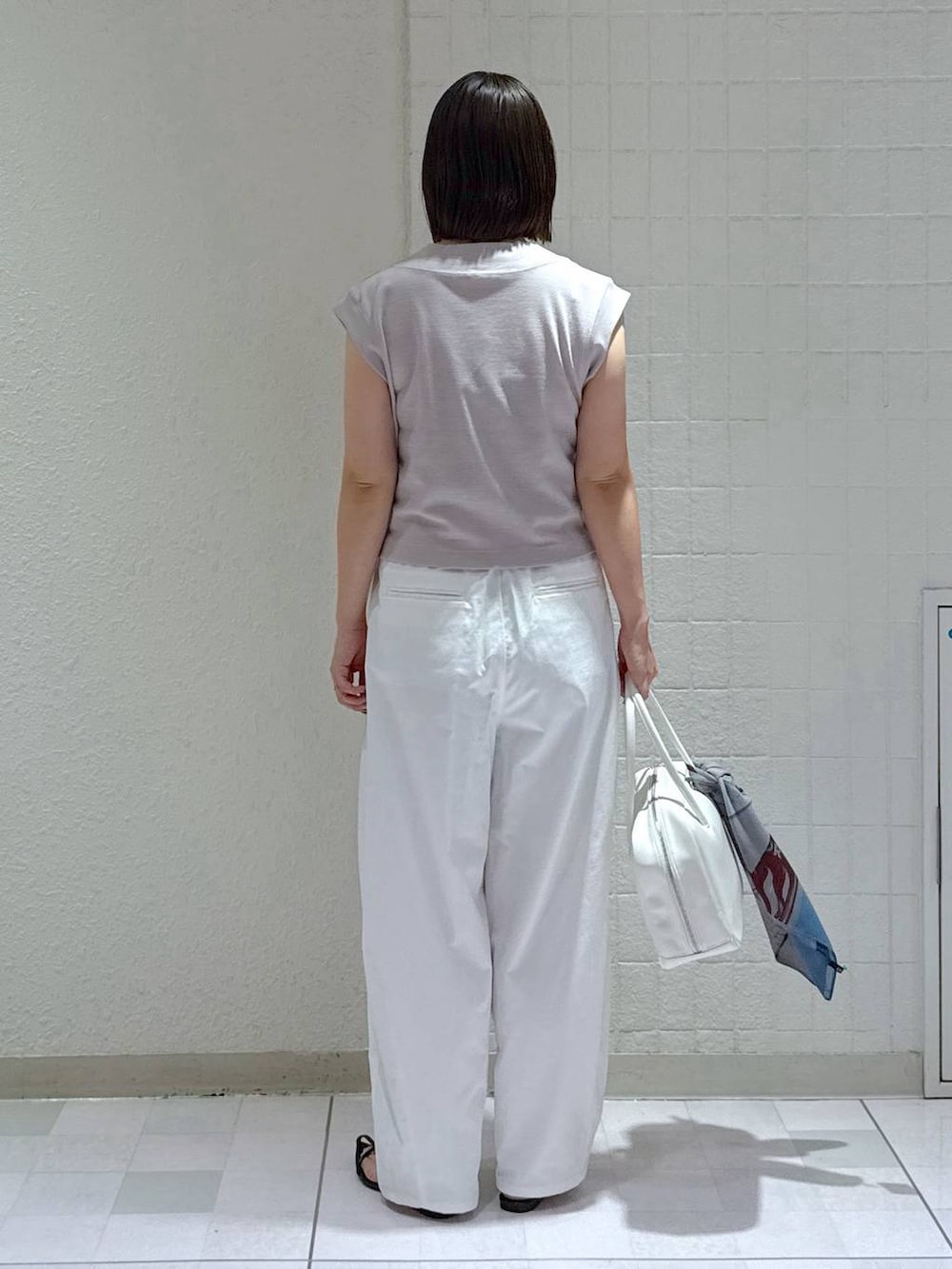 ホワイト系のボストンバッグ、ブラック系のサンダル、ホワイト系のその他パンツを着用したレディースの夏コーディネートの3枚目の写真