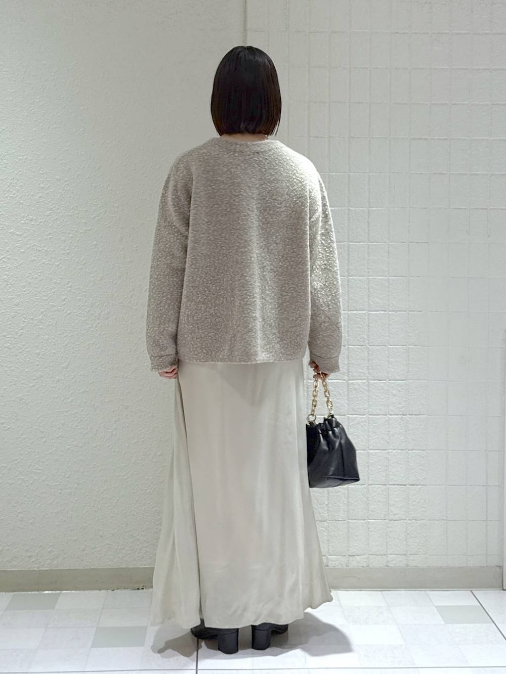 ブラック系のブーツ、ベージュ系のカーディガン/ボレロ、ブラック系のショルダーバッグを着用したレディースの秋コーディネートの4枚目の写真