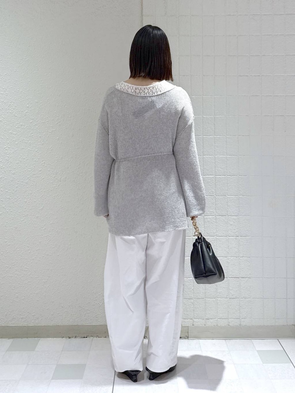 ホワイト系のTシャツ/カットソー、ブラック系のショルダーバッグ、グレー系のカーディガン/ボレロを着用したレディースの春コーディネートの3枚目の写真