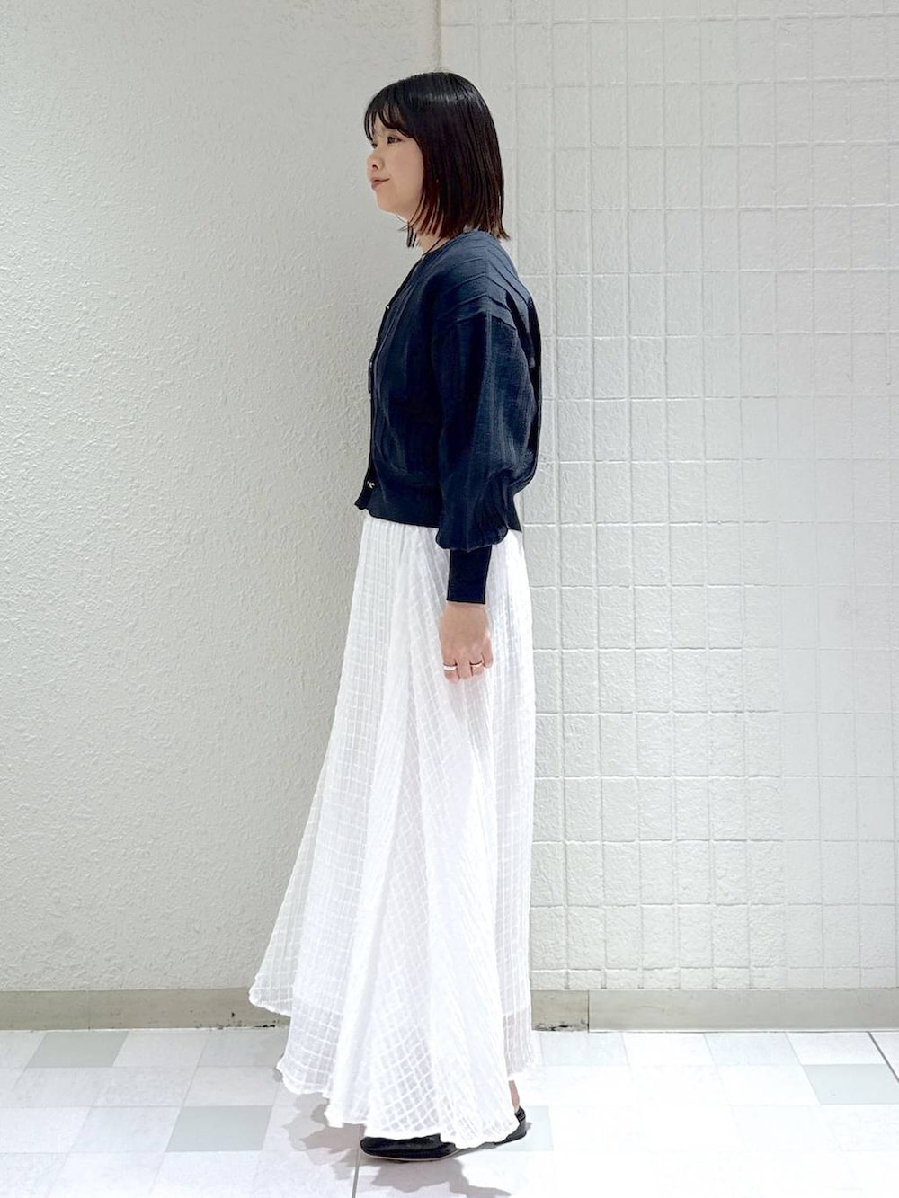 ブルー系のカーディガン/ボレロ、ブラック系のショルダーバッグ、ブラック系のパンプスを着用したレディースの春コーディネートの5枚目の写真