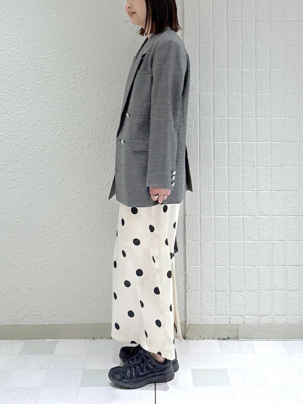 ブラック系のショルダーバッグ、ブラック系のテーラードジャケット、ホワイト系のワンピースを着用したレディースの冬コーディネートの5枚目の写真