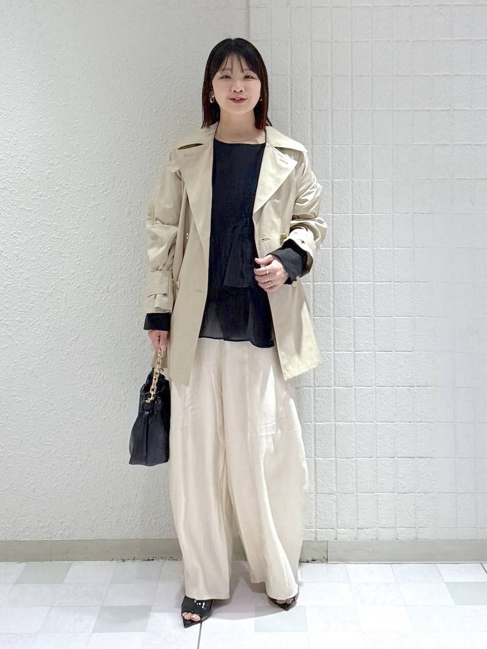 ホワイト系のその他パンツ、ブラック系のショルダーバッグ、ブラック系のシャツ/ブラウスを着用したレディースの春コーディネートの2枚目の写真