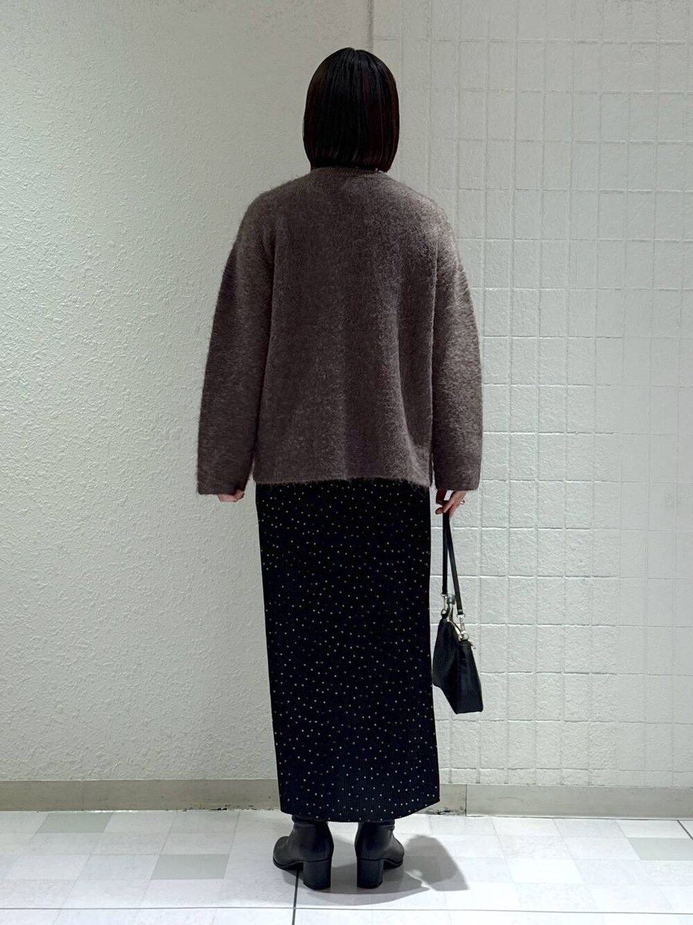 ブラック系のブーツ、その他のスカート、ブラウン系のカーディガン/ボレロを着用したレディースの秋コーディネートの4枚目の写真