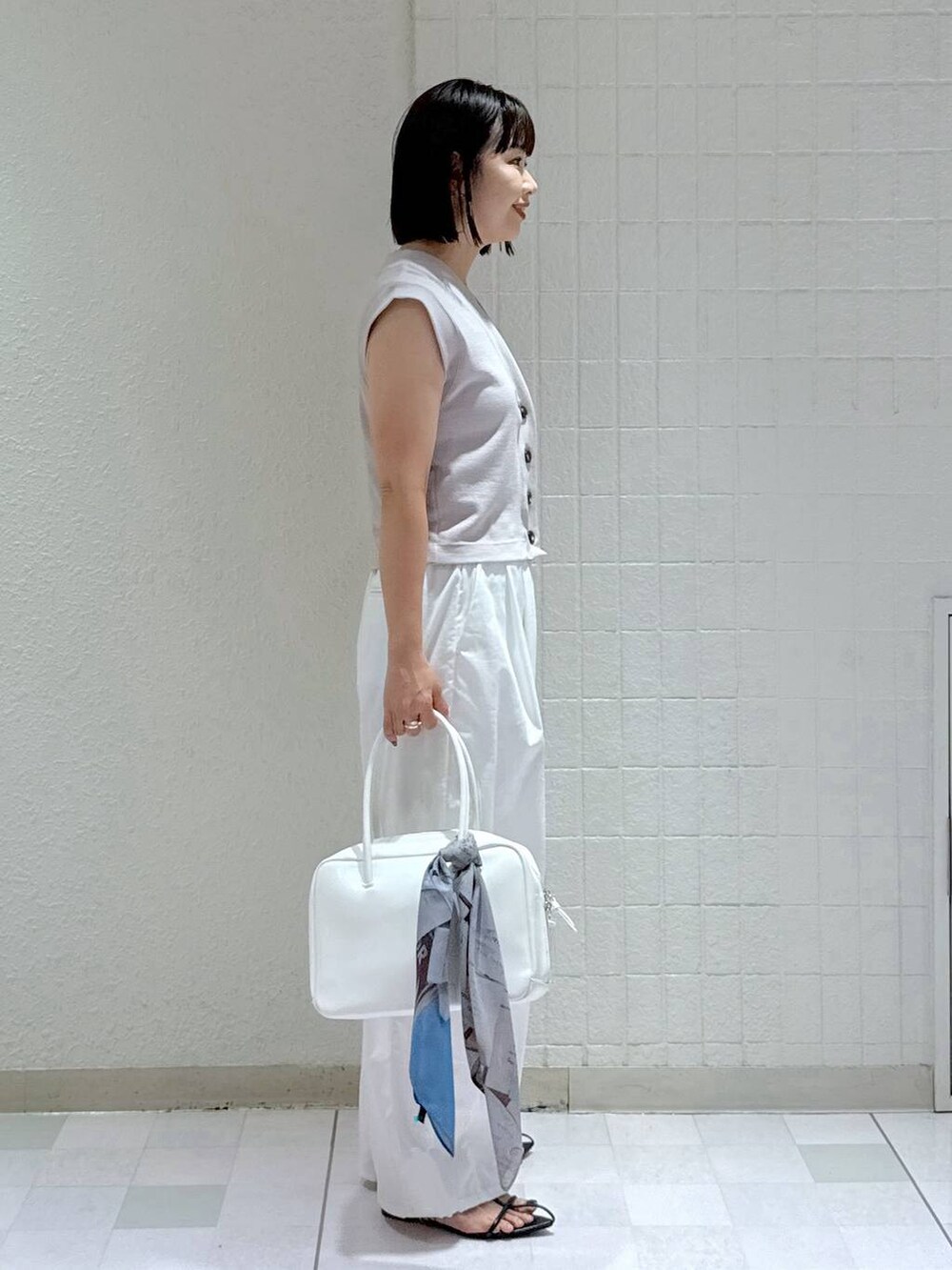 ホワイト系のボストンバッグ、ブラック系のサンダル、ホワイト系のその他パンツを着用したレディースの夏コーディネートの2枚目の写真