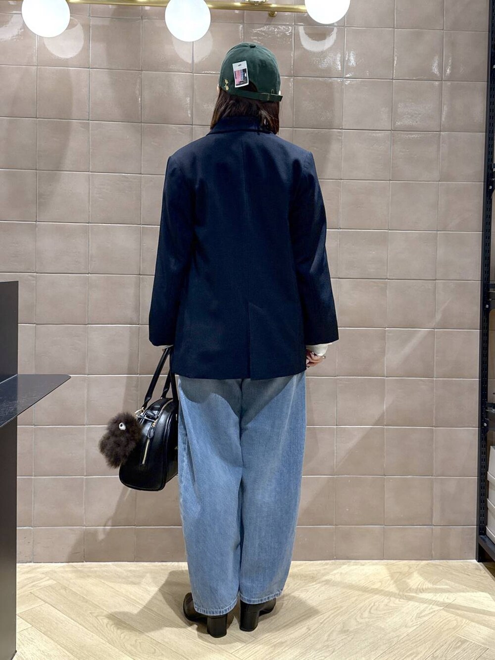 ブルー系のデニムパンツ、ブラック系のブーツ、ブルー系のテーラードジャケットを着用したレディースの秋コーディネートの4枚目の写真