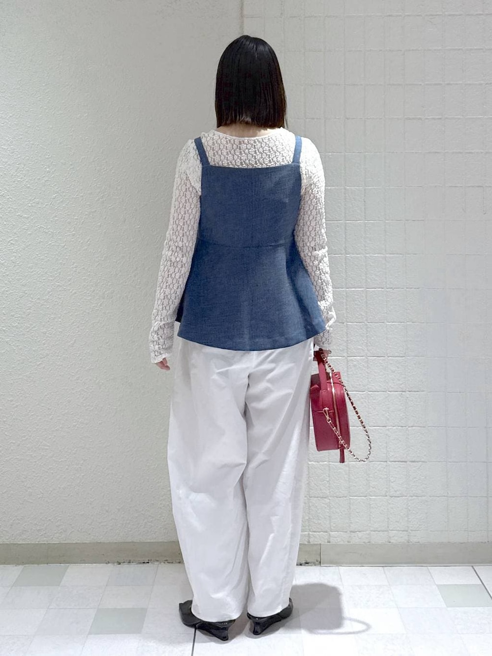 ホワイト系のTシャツ/カットソー、ブルー系のベスト、ブラック系のサンダルを着用したレディースの春コーディネートの3枚目の写真