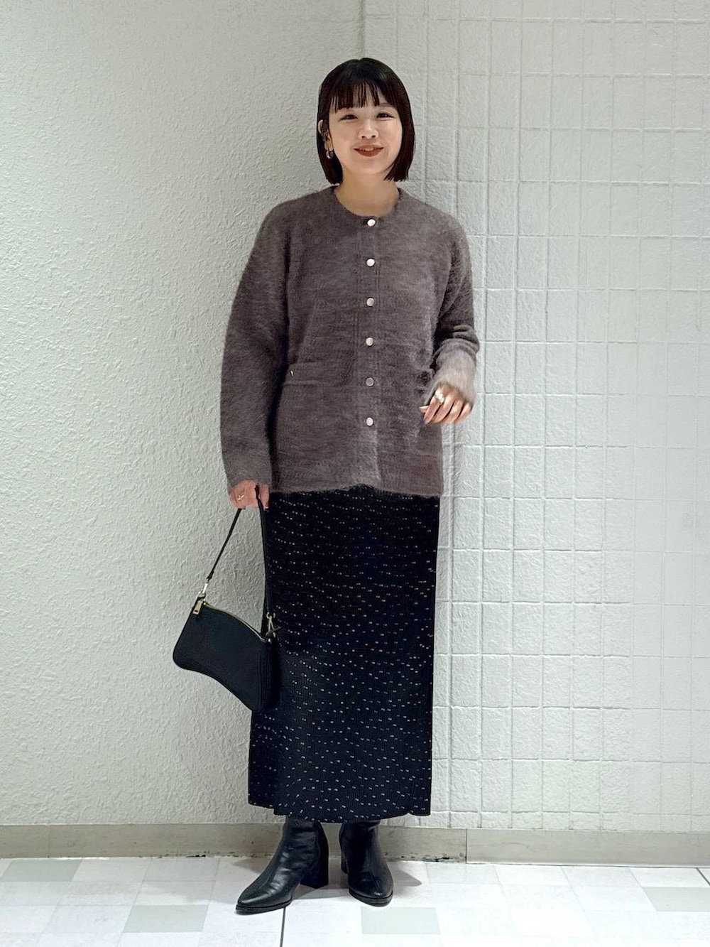 ブラック系のブーツ、その他のスカート、ブラウン系のカーディガン/ボレロを着用したレディースの秋コーディネートの2枚目の写真
