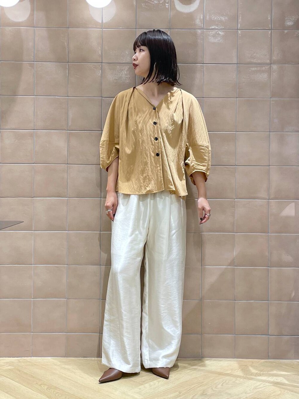 ブラウン系のパンプス、ホワイト系のその他パンツ、オレンジ系のシャツ/ブラウスを着用したレディースの夏コーディネートの6枚目の写真