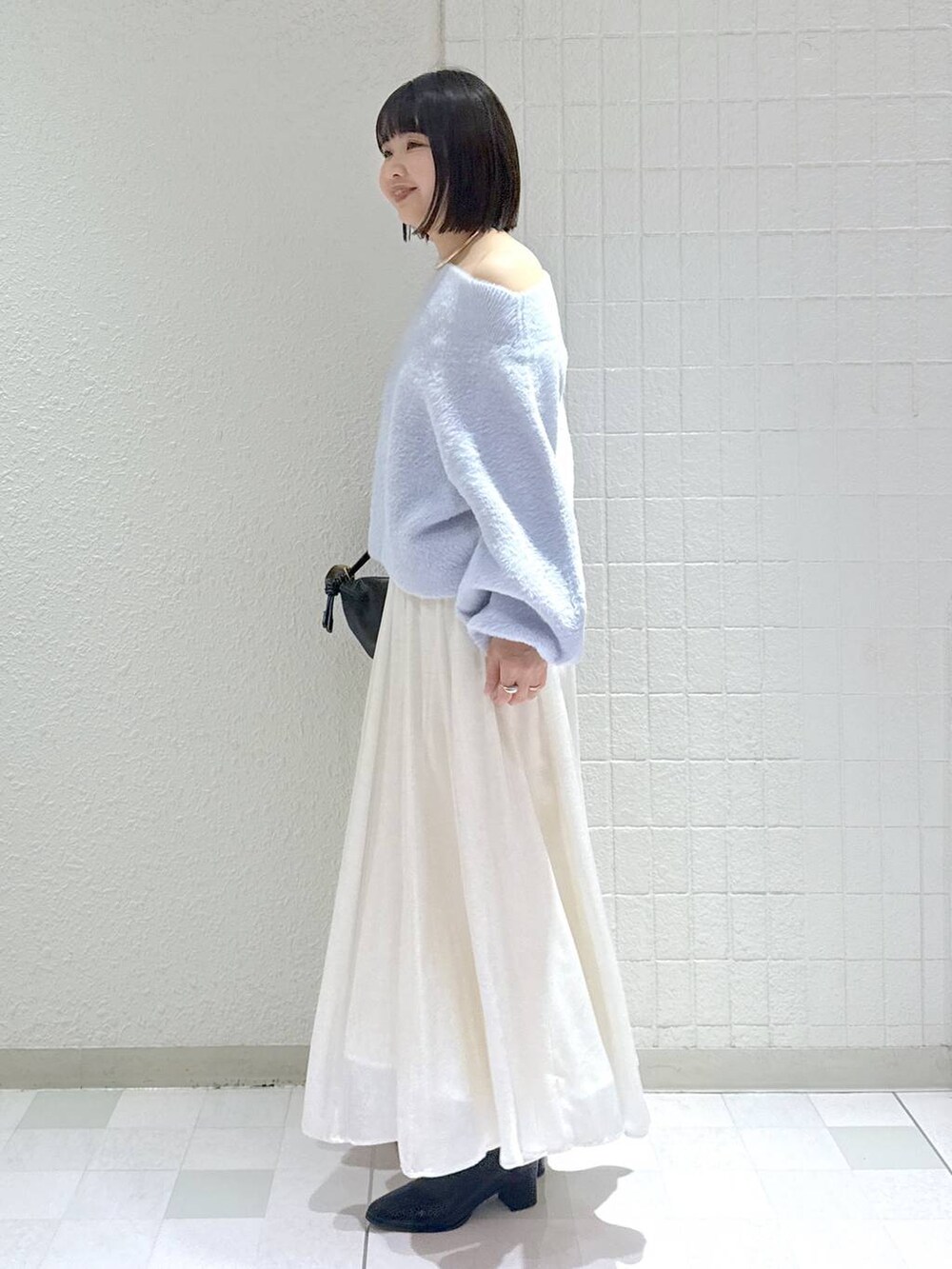 ブラック系のブーツ、ブラック系のショルダーバッグ、ブルー系のニット/セーターを着用したレディースの冬コーディネートの5枚目の写真