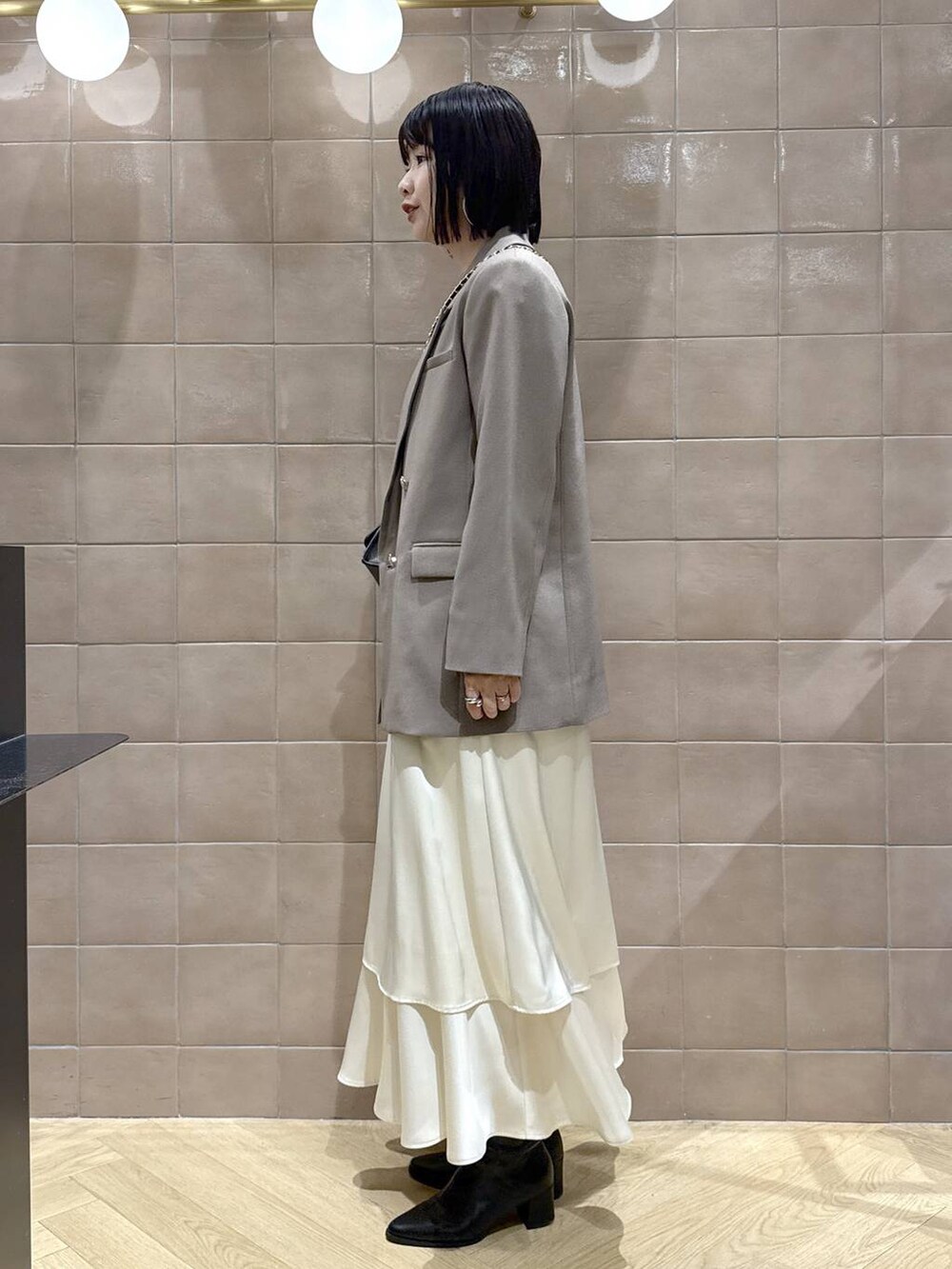 ブラック系のブーツ、グレー系のテーラードジャケット、ホワイト系のワンピースを着用したレディースの秋コーディネートの5枚目の写真