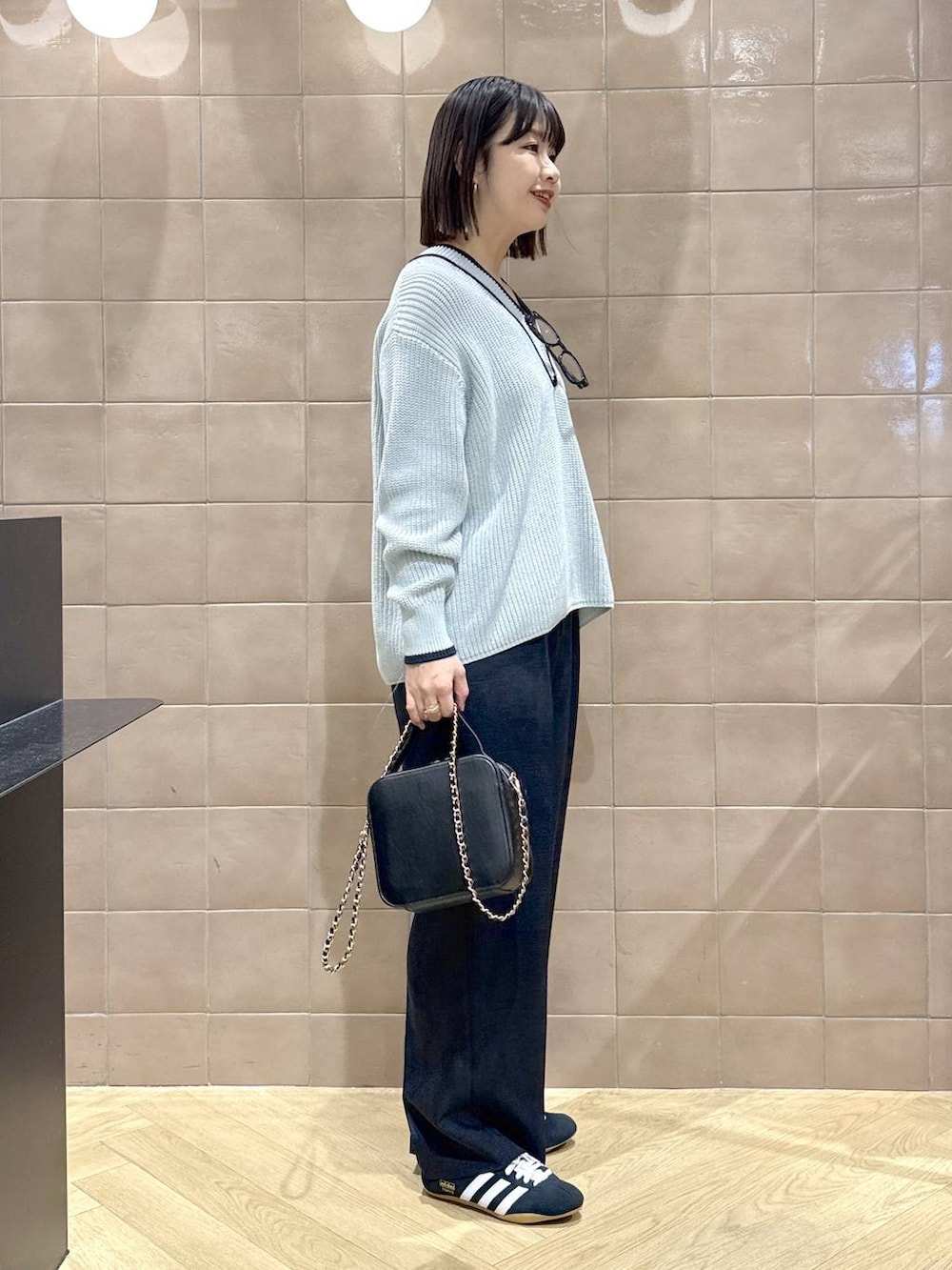 ブラック系のスニーカー、ブルー系のスラックス、ブルー系のニット/セーターを着用したレディースの冬コーディネートの3枚目の写真