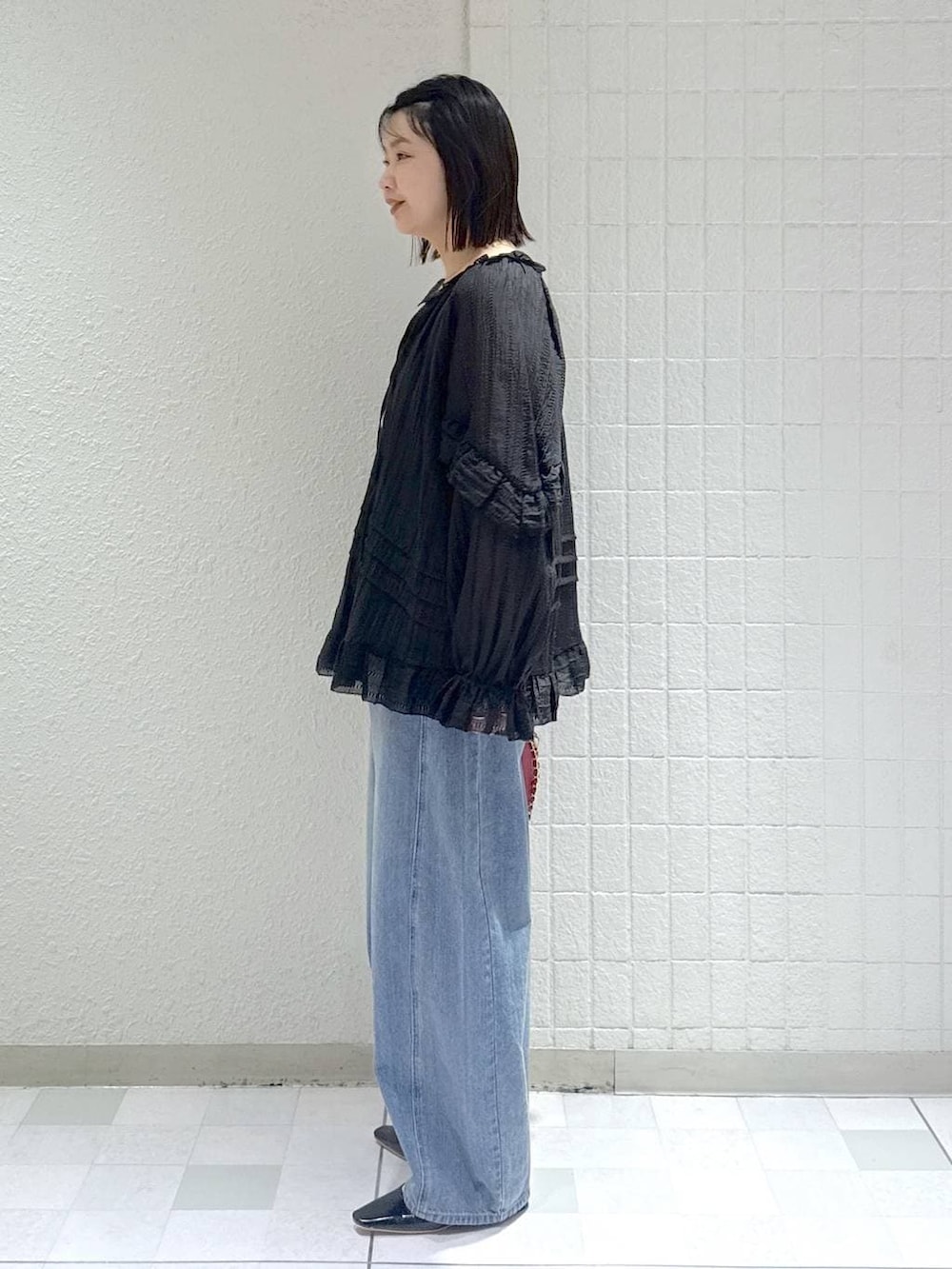 ブルー系のデニムパンツ、ブラック系のシャツ/ブラウス、ブラック系のパンプスを着用したレディースの春コーディネートの4枚目の写真