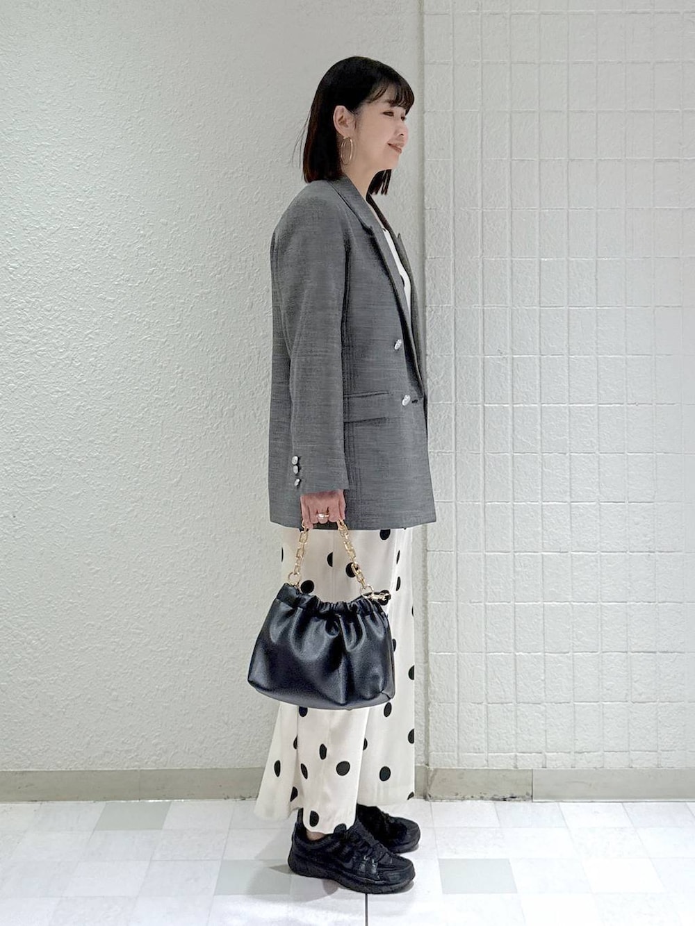 ブラック系のショルダーバッグ、ブラック系のテーラードジャケット、ホワイト系のワンピースを着用したレディースの冬コーディネートの3枚目の写真