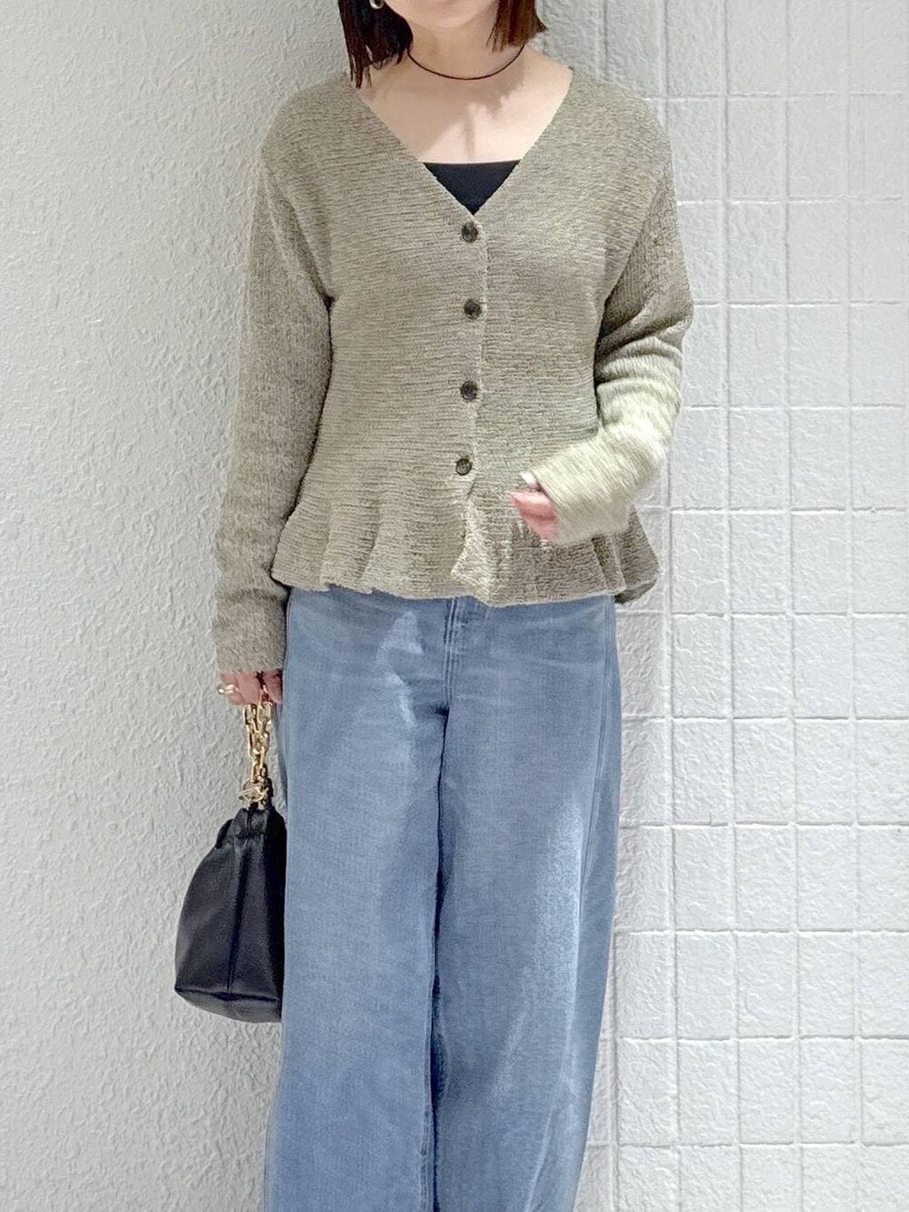 ブルー系のデニムパンツ、ブラック系のショルダーバッグ、ブラック系のパンプスを着用したレディースの春コーディネートの5枚目の写真