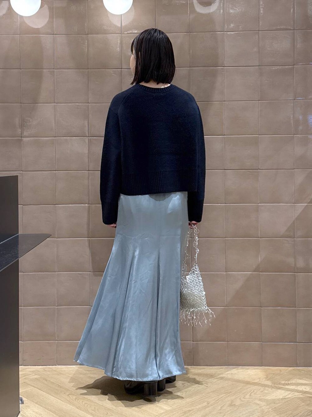 ブルー系のニット/セーター、ブルー系のスカート、ブラック系のブーツを着用したレディースの冬コーディネートの2枚目の写真