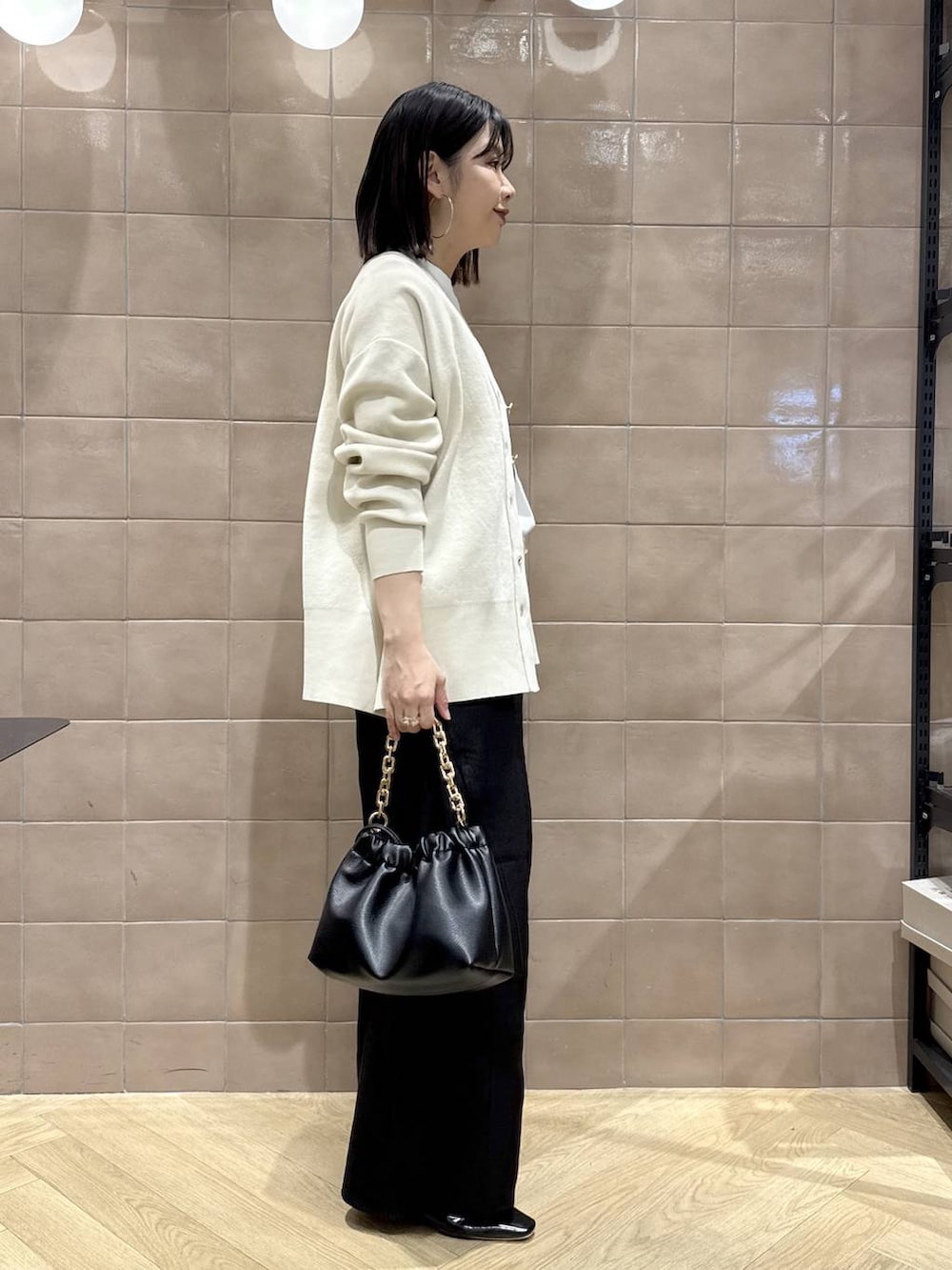 ホワイト系のカーディガン/ボレロ、ブラック系のその他パンツ、ブラック系のショルダーバッグを着用したレディースの春コーディネートの2枚目の写真