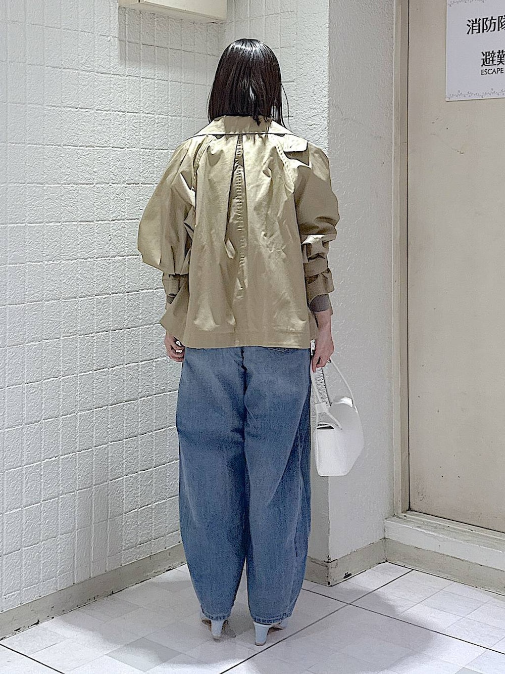 ブルー系のデニムパンツ、グレー系のカーディガン/ボレロ、ベージュ系のトレンチコートを着用したレディースの冬コーディネートの4枚目の写真