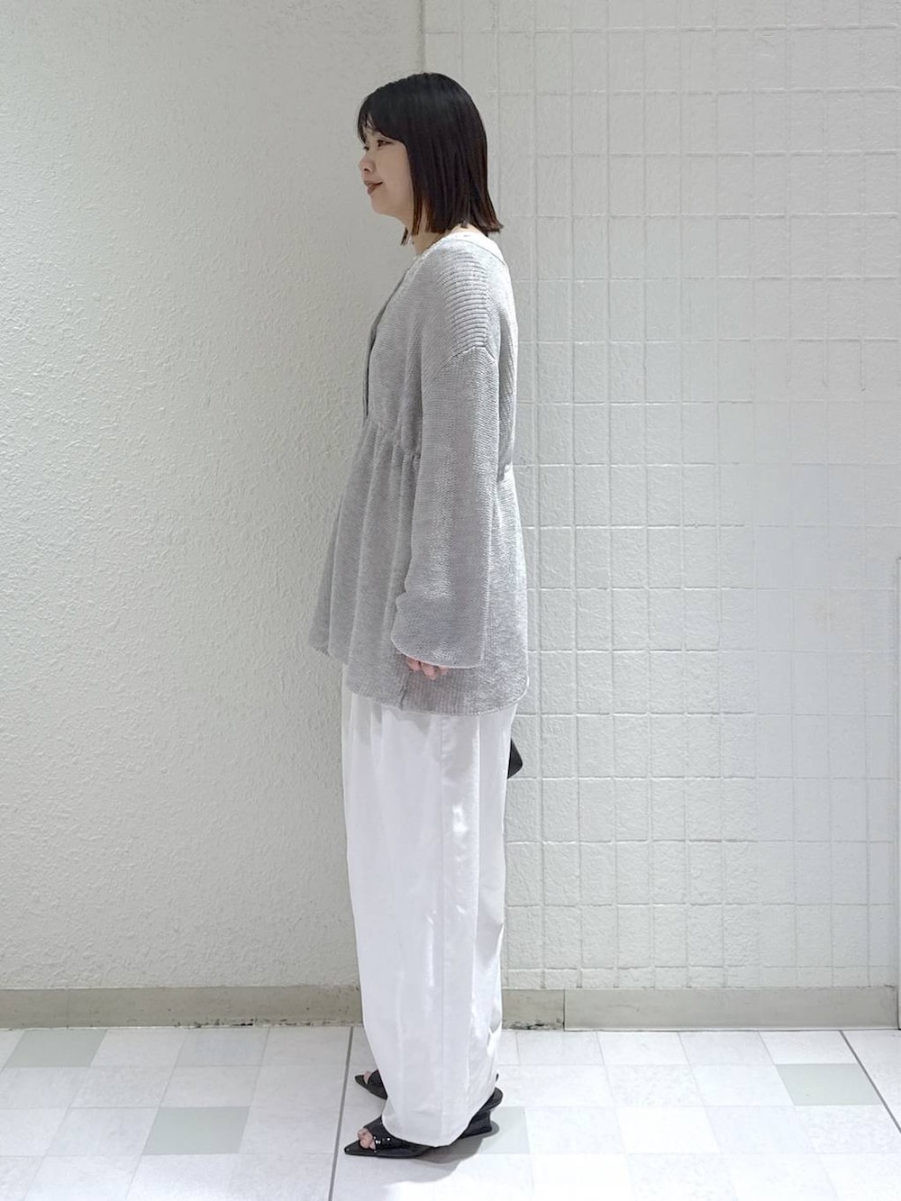 ホワイト系のTシャツ/カットソー、ブラック系のショルダーバッグ、グレー系のカーディガン/ボレロを着用したレディースの春コーディネートの4枚目の写真