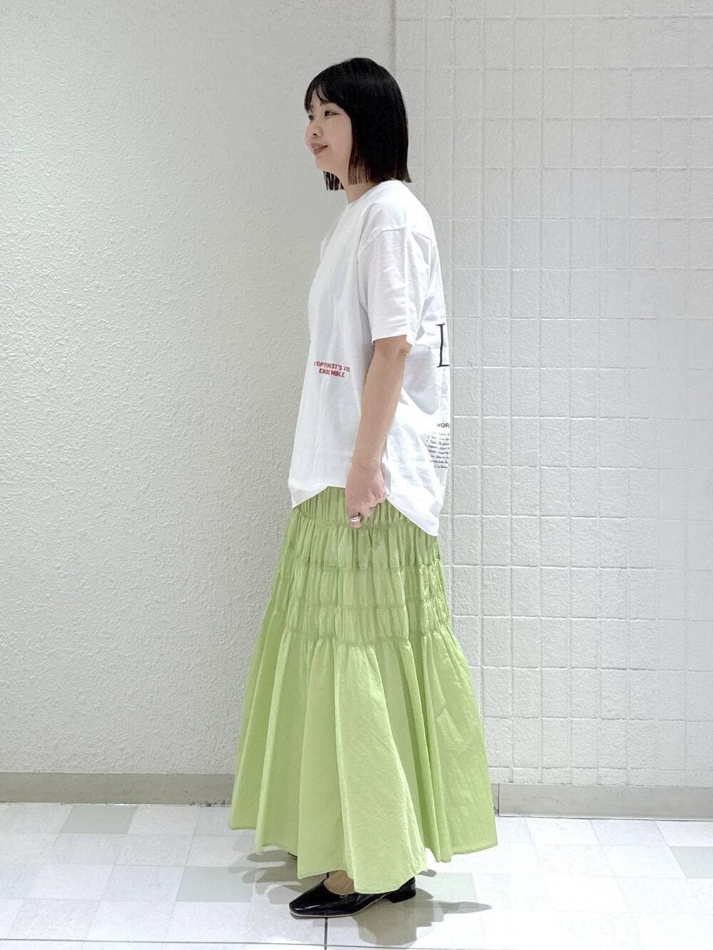 ベージュ系のショルダーバッグ、グリーン系のスカート、ブラック系のその他シューズを着用したレディースの冬コーディネートの4枚目の写真